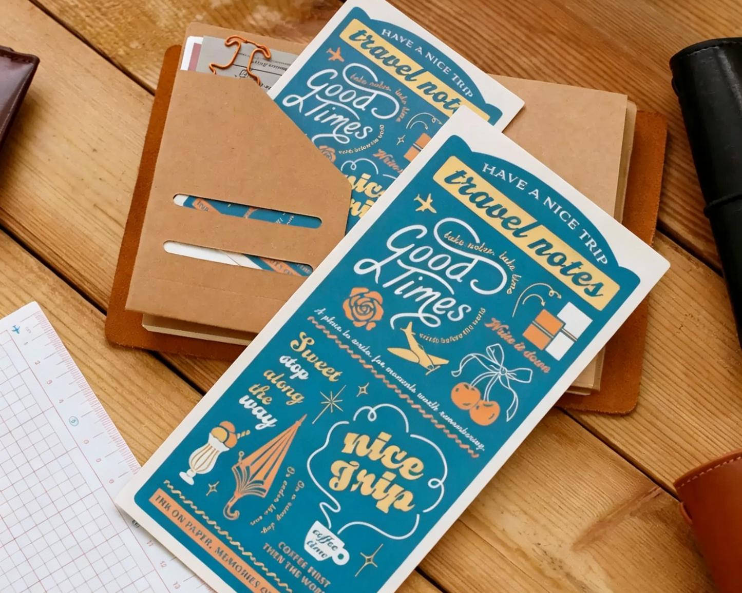 Two travel notebooks with decorative covers on a wooden surface.