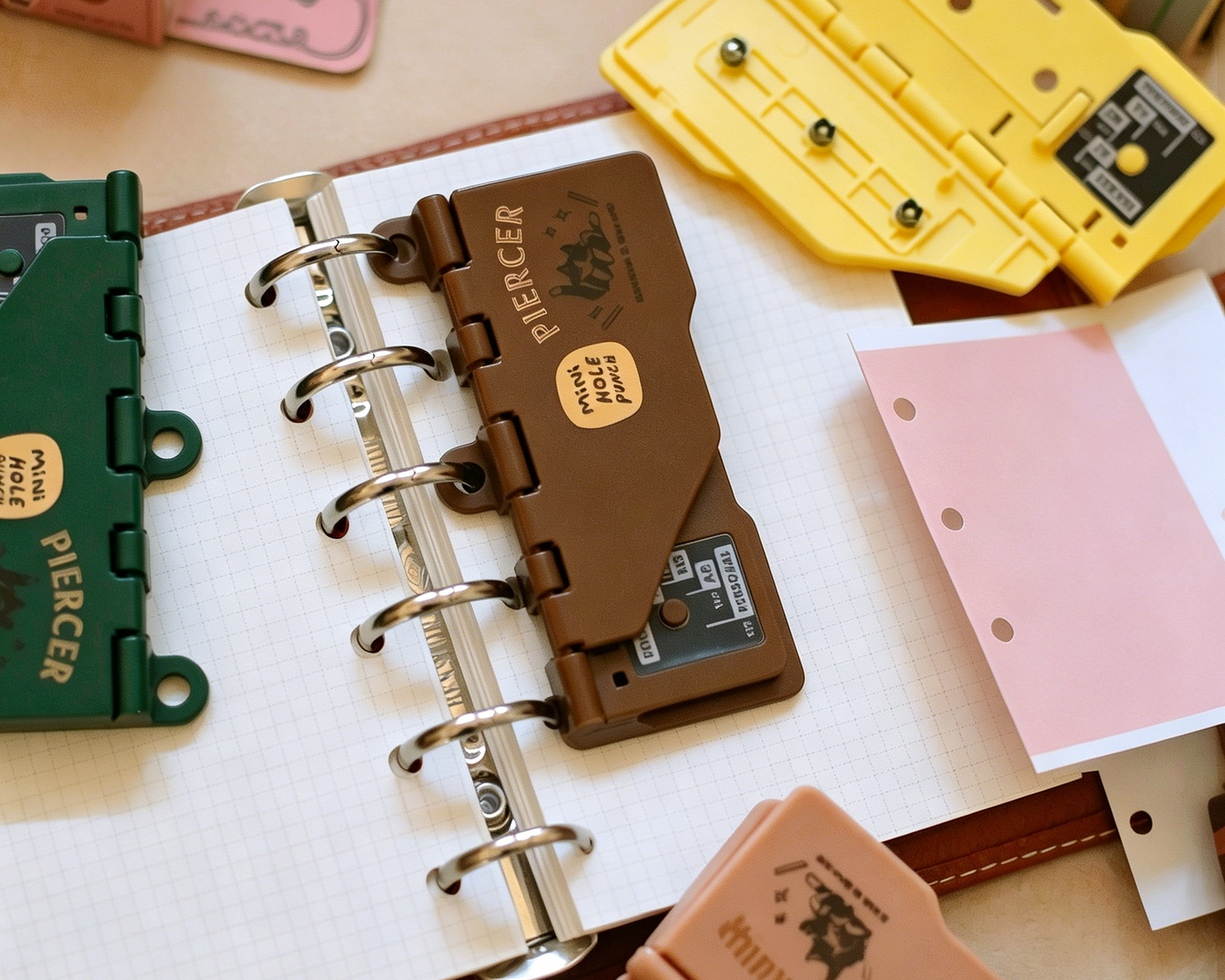 Mini portable 3 hole punch for journals and planners in yellow pink brown and green